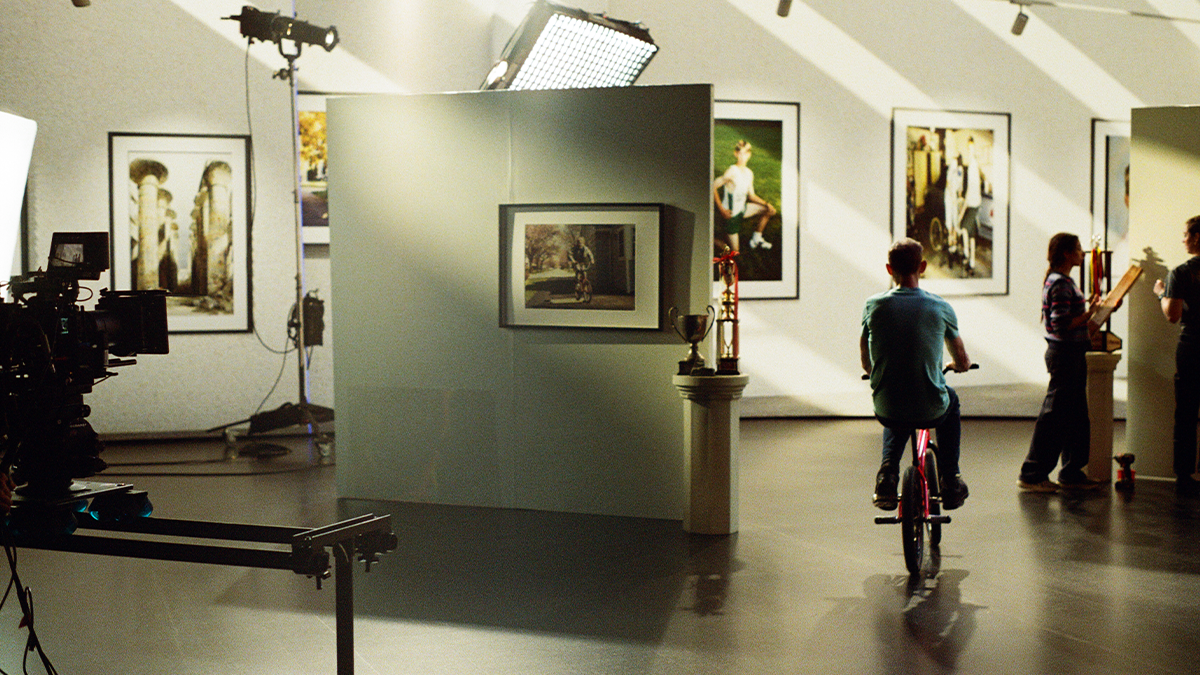 A Professional BMX biker rides his bike on a virtual production set at an LED Virtual production studio while a film crew captures it.