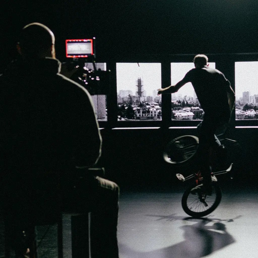 A cinematographer operates a cinema camera to film a BMX biker