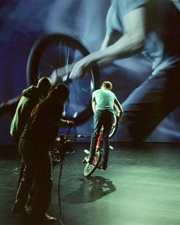 A cinematographer and camera operator capture a shot of a BMX biker in front of an LED virtual production wall