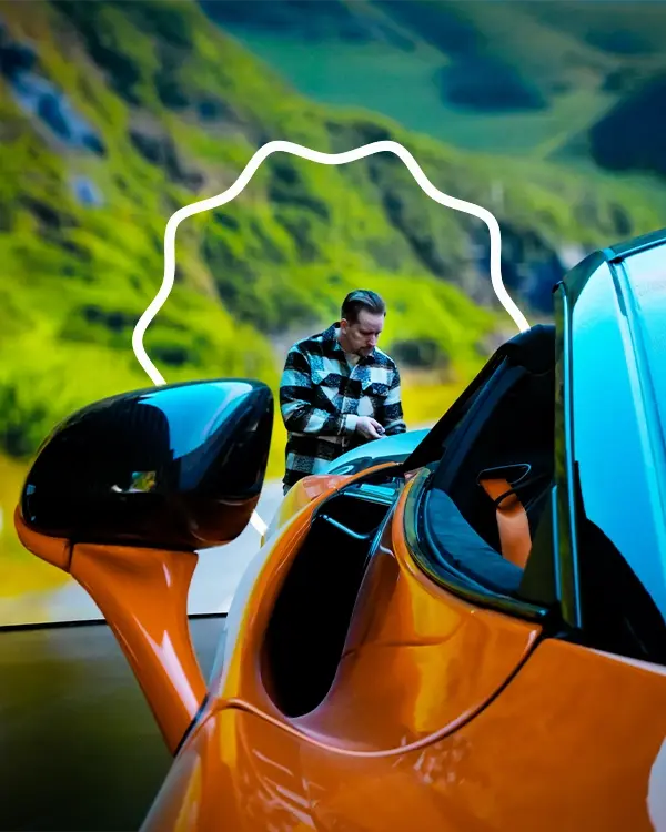 A cinematographer filming a sports car on a virtual production stage