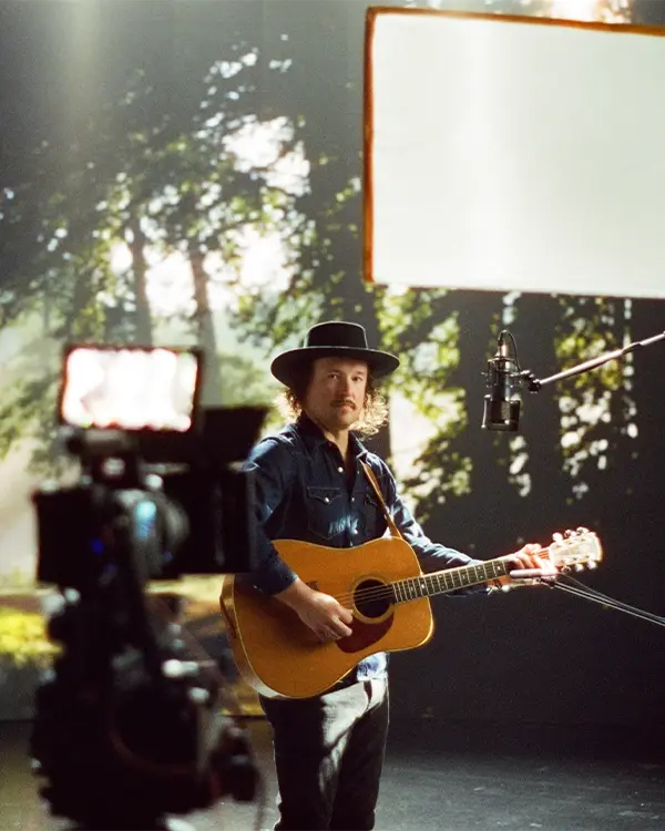 A musician performs for a music video shot on a RED cinema camera in an LED virtual production stage
