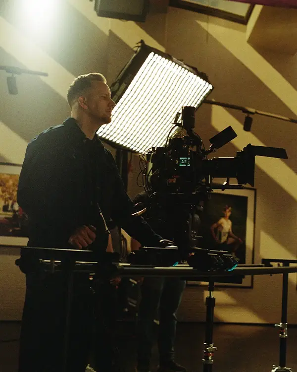 A cinematographer operating a cinema camera on a dolly