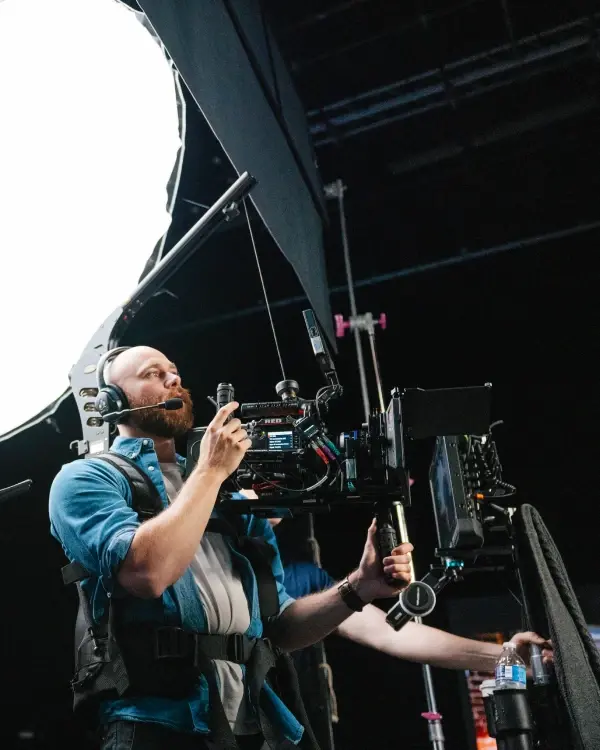 A cinematographer operating a cinema camera on an easy rig