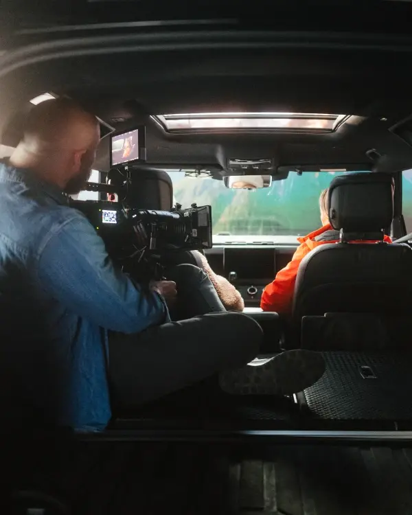 A cinematographer filming a car process virtual production project